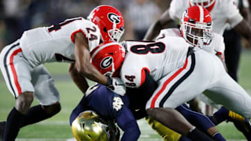 SOUTH BEND, IN - SEPTEMBER 09: Walter Grant #84 and Dominick Sanders #24 of the Georgia Bulldogs make a tackle against the Notre Dame Fighting Irish in the first quarter of a game at Notre Dame Stadium on September 9, 2017 in South Bend, Indiana. (Photo by Joe Robbins/Getty Images)