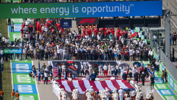 Oct 24, 2021; Austin, TX, USA; A view of the starting grid of drivers and the US flag and the Formula One flag and the University of Texas marching band before the start of the United States Grand Prix Race at Circuit of the Americas. Mandatory Credit: Jerome Miron-USA TODAY Sports