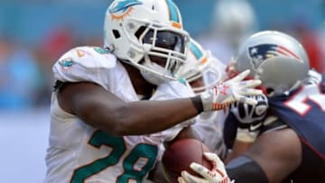 Sep 7, 2014; Miami Gardens, FL, USA; Miami Dolphins running back Knowshon Moreno (28) runs against the New England Patriots defense during the second half at Sun Life Stadium. The Dolphins won 33-20. Mandatory Credit: Steve Mitchell-USA TODAY Sports