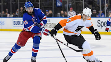 Apr 3, 2022; New York, New York, USA; New York Rangers center Mika Zibanejad (93) attempts to steal the puck form Philadelphia Flyers defenseman Travis Sanheim (6) during overtime at Madison Square Garden. Mandatory Credit: Dennis Schneidler-USA TODAY Sports