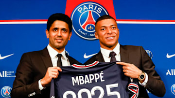 PARIS, FRANCE - MAY 23: Nasser Al-Khelaifi talks PSG president (L) and Kylian Mbappe (R) poses for photos with 2025 PSG t-shirt indicates the new contract of Mbappe during the Press Conference of Paris Saint-Germain at Parc des Princes on May 23, 2022 in Paris, France. (Photo by Antonio Borga/Eurasia Sport Images/Getty Images)