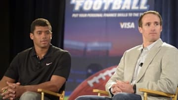 Jan 30, 2013; New Orleans, LA, USA; Seattle Seahawks quarterback Russell Wilson and New Orleans Saints quarterback Drew Brees joined Louisiana state treasurer John Kennedy in a high energy game of financial football between the two teams made up of local high school students at the New Orleans convention center. Mandatory Credit: John David Mercer-USA TODAY Sports