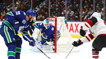 VANCOUVER, BC - JANUARY 16: Vancouver Canucks Goalie Jacob Markstrom (25) watches Arizona Coyotes Right Wing Conor Garland (83) and Vancouver Canucks Defenceman Alexander Edler (23) battle for the puck near the net during their NHL game at Rogers Arena on January 16, 2020 in Vancouver, British Columbia, Canada.(Photo by Devin Manky/Icon Sportswire via Getty Images)