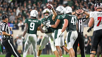 EAST LANSING, MICHIGAN - OCTOBER 02: Cal Haladay #27, Ronald Williams #9 and Xavier Henderson #3 of the Michigan State Spartans celebrate after recovering a fumble against the Western Kentucky Hilltoppers during the second quarter of the game at Spartan Stadium on October 02, 2021 in East Lansing, Michigan. (Photo by Nic Antaya/Getty Images)