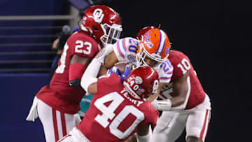 Dec 30, 2020; Arlington, TX, USA; Oklahoma Sooners linebacker DaShaun White (23) and safety Pat Fields (10) and linebacker Jon-Michael Terry (40) tackle Florida Gators running back Malik Davis (20) during the second half at AT&T Stadium. Mandatory Credit: Kevin Jairaj-USA TODAY Sports