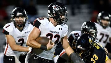 St. Johns' Konnor Near, wearing a padded cast on his left hand, runs the ball during the second quarter on Friday, Sept. 28, 2018, in Haslett.Vikings Redwings