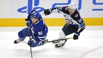 Mar 13, 2021; Toronto, Ontario, CAN; Winnipeg Jets forward Mark Scheifele (55) earns a minor penalty for tripping Toronto Maple Leafs forward John Tavares (91) in the first period at Scotiabank Arena. Mandatory Credit: Dan Hamilton-USA TODAY Sports