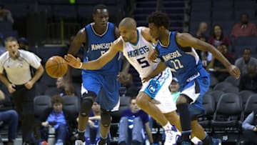 Oct 10, 2016; Charlotte, NC, USA; Charlotte Hornets guard Nicolas Batum (5) dribbles the ball between Minnesota Timberwolves center Gorgui Dieng (5) and forward Andrew Wiggins (22) during the second half at Time Warner Cable Arena. The Hornets won 98-86. Mandatory Credit: Joshua S. Kelly-USA TODAY Sports