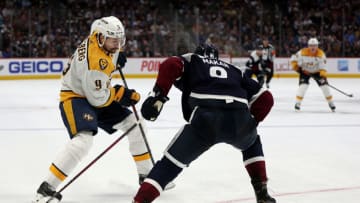 Filip Forsberg #9 of the Nashville Predators advances the puck against Cale Makar #8 of the Colorado Avalanche in the first period at Ball Arena on April 28, 2022 in Denver, Colorado. (Photo by Matthew Stockman/Getty Images)