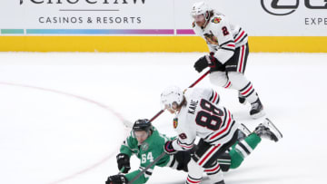 DALLAS, TEXAS - FEBRUARY 09: Tanner Kero #64 of the Dallas Stars get tripped up by Dominik Kubalik #8 of the Chicago Blackhawks and Duncan Keith #2 of the Chicago Blackhawks in the second period at American Airlines Center on February 09, 2021 in Dallas, Texas. (Photo by Tom Pennington/Getty Images)