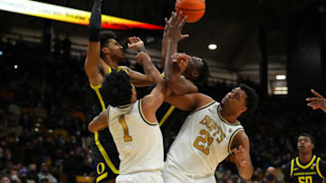 Feb 3, 2022; Boulder, Colorado, USA; Oregon Ducks guard Rivaldo Soares (11) and center N'Faly Dante (1) and Colorado Buffaloes guard Julian Hammond III (1) and forward Evan Battey (21) reach for a rebound in the second half at CU Events Center. Mandatory Credit: Ron Chenoy-USA TODAY Sports