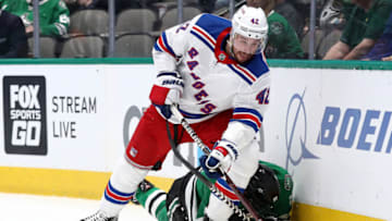 DALLAS, TEXAS - MARCH 10: Brendan Smith #42 of the New York Rangers skates the puck against Tyler Seguin #91 of the Dallas Stars during the first period at American Airlines Center on March 10, 2020 in Dallas, Texas. (Photo by Ronald Martinez/Getty Images)