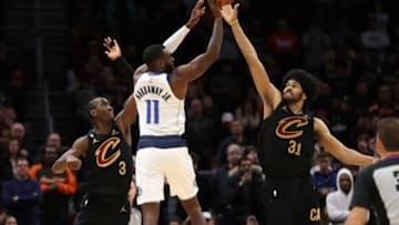 Dec 17, 2022; Cleveland, Ohio, USA; Dallas Mavericks guard Tim Hardaway Jr. (11) shoots the ball over Cleveland Cavaliers guard Caris LeVert (3) and center Jarrett Allen (31) during overtime at Rocket Mortgage FieldHouse. Mandatory Credit: Aaron Josefczyk-USA TODAY Sports