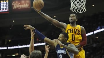 Feb 9, 2014; Cleveland, OH, USA; Cleveland Cavaliers shooting guard C.J. Miles (0) reaches for a missed shot against Memphis Grizzlies power forward James Johnson in the fourth quarter at Quicken Loans Arena. Mandatory Credit: David Richard-USA TODAY Sports