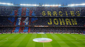 Football supporters hold-up coloured rectangular posters to form a giant mosaic reading, "Thankyou Johan", (Photo credit should read PAU BARRENA/AFP via Getty Images)
