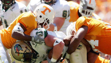 KNOXVILLE, TN - SEPTEMBER 3: Dan Burks #34 of the UAB Blazers is brought down by Jason Hall #94 and Raymond Henderson #97 of the Tennessee Volunteers on September 3, 2005 at Neyland Stadium in Knoxville, Tennessee. (Photo by Elsa/Getty Images)