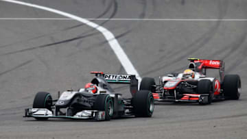 SHANGHAI, CHINA - APRIL 18: Michael Schumacher (red helmet) of Germany and Mercedes GP and Lewis Hamilton (yellow helmet) of Great Britain and McLaren Mercedes fight for position as they drive during the Chinese Formula One Grand Prix at the Shanghai International Circuit on April 18, 2010 in Shanghai, China. (Photo by Paul Gilham/Getty Images)