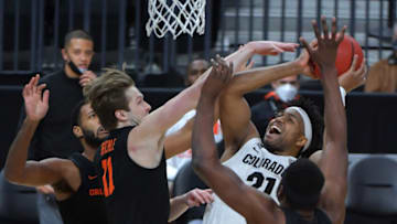 Mar 13, 2021; Las Vegas, NV, USA; Colorado Buffaloes forward Evan Battey (21) looks to shoot as Oregon State Beavers guard Zach Reichle (11) and Oregon State Beavers forward Rodrigue Andela (34) defend during the first half at T-Mobile Arena. Mandatory Credit: Stephen R. Sylvanie-USA TODAY Sports
