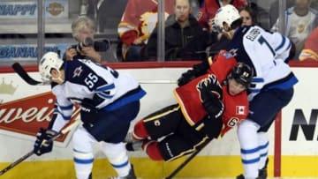 Oct 2, 2014; Calgary, Alberta, CAN; Calgary Flames center Sam Bennett (63) collides with Winnipeg Jets center Mark Scheifele (55) and defenseman Keaton Ellerby (7) in the second period of preseason action at Scotiabank Saddledome. Flames won 4-2. Mandatory Credit: Candice Ward-USA TODAY Sports