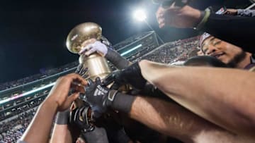 Mississippi State Bulldogs reach to get a hand on the Egg Bowl trophy after defeating Ole Miss 21-20 at Davis Wade Stadium Thursday in Starkville Nov.28, 2019.Egg Bowl 18