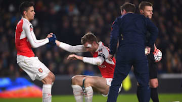 HULL, ENGLAND - MARCH 08: Gabriel Paulista of Arsenal helps Per Mertesacker to his feet after a clash of heads during the Emirates FA Cup Fifth Round Replay match between Hull City and Arsenal at KC Stadium on March 8, 2016 in Hull, England. (Photo by Laurence Griffiths/Getty Images)