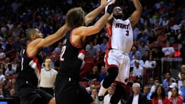 Mar 18, 2015; Miami, FL, USA; Miami Heat guard Dwyane Wade (3) shoots the ball as Portland Trail Blazers center Robin Lopez (42) and forward Nicolas Batum (left) defend in the second half at American Airlines Arena. The Heat won 108-104. Mandatory Credit: Robert Mayer-USA TODAY Sports