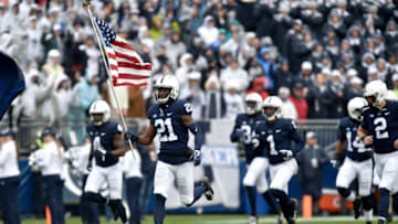 STATE COLLEGE, PA - OCTOBER 27: Penn State CB Amani Oruwariye (21) leads the team onto the field carrying an American flag on Military Appreciation Day. The Penn State Nittany Lions defeated the Iowa Hawkeyes 30-24 on October 27, 2018 at Beaver Stadium in State College, PA. (Photo by Randy Litzinger/Icon Sportswire via Getty Images)