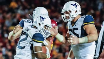 Nov 26, 2016; Ames, IA, USA; West Virginia Mountaineers running back Martell Pettaway (32) celebrates his touchdown run with tight end Elijah Wellman (28) and offensive lineman Tyler Orlosky (65) during the third quarter against the Iowa State Cyclones at Jack Trice Stadium. Mandatory Credit: Jeffrey Becker-USA TODAY Sports