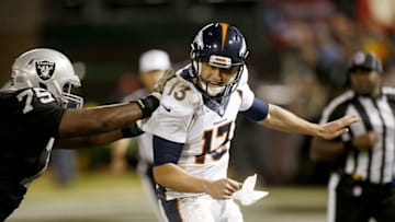 Nov 6, 2016; Oakland, CA, USA; Denver Broncos quarterback Trevor Siemian (13) is tackled by Oakland Raiders defensive tackle Darius Latham (75) after throwing an incomplete pass in the fourth quarter at Oakland Coliseum. The Raiders defeated the Broncos 30-20. Mandatory Credit: Cary Edmondson-USA TODAY Sports