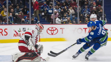 Dec 12, 2021; Vancouver, British Columbia, CAN; Carolina Hurricanes goalie Antti Raanta (32) makes a save on Vancouver Canucks forward Juho Lammikko (91) in the third period at Rogers Arena. Vancouver won 2-1. Mandatory Credit: Bob Frid-USA TODAY Sports