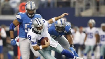 Jan 4, 2015; Arlington, TX, USA; Dallas Cowboys quarterback Tony Romo (9) tries to escape the pressure by Detroit Lions defensive end Ezekiel Ansah (94) and Darryl Tapp (52) during the second quarter in the NFC Wild Card Playoff Game at AT&T Stadium. Mandatory Credit: Tim Heitman-USA TODAY Sports