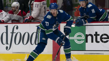 VANCOUVER, BC - JANUARY 20: Travis Hamonic #27 of the Vancouver Canucks skates with the puck during NHL hockey action against the Montreal Canadiens at Rogers Arena on January 20, 2021 in Vancouver, Canada. (Photo by Rich Lam/Getty Images)