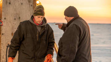 Captain Kris Kelly walks by as brother Andy Kelly points on the ice. Bering Sea Gold. Image Courtesy Discovery Channel