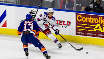BRIDGEPORT, CT - SEPTEMBER 22: New York Rangers Defenseman John Gilmour #58 passes the puck around New York Islanders Center Mathew Barzal #13 during the second period of a preseason NHL game between the New York Rangers and the New York Islanders on September 22, 2018, at Webster Bank Arena in Bridgeport, CT. (Photo by David Hahn/Icon Sportswire via Getty Images)