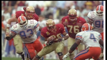 30 Nov 1996: Running back Warrick Dunn of the Florida State Seminoles moves the ball as several Florida Gators players prepare to tackle him during a game at Doak S. Campbell Stadium in Tallahassee, Florida. FSU won the game, 24-21. Mandatory Credit: An