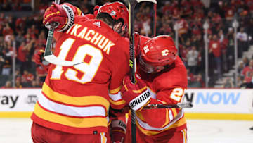 Apr 12, 2022; Calgary, Alberta, CAN; Calgary Flames forward Matthew Tkachuk (19) celebrates his goal with forward Johnny Gaudreau (13) and forward Elias Lindholm (28) against the Seattle Kraken at Scotiabank Saddledome. Mandatory Credit: Candice Ward-USA TODAY Sports