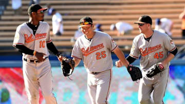 Jul 6, 2016; Los Angeles, CA, USA; Baltimore Orioles center fielder Adam Jones (10), left fielder Hyun Soo Kim (25) and right fielder Mark Trumbo (45) head in from the outfield after defeating the Los Angeles Dodgers in14th innings at Dodger Stadium. Orioles won 6-4 in the 14th inning. Mandatory Credit: Jayne Kamin-Oncea-USA TODAY Sports