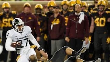 MINNEAPOLIS, MN - OCTOBER 14: Nate Wozniak #80 of the Minnesota Golden Gophers tackles Khari Willis #27 of the Michigan State Spartans after an interception as head coach P.J. Fleck of the Minnesota Golden Gophers looks on during the second quarter of the game on October 14, 2017 at TCF Bank Stadium in Minneapolis, Minnesota. (Photo by Hannah Foslien/Getty Images)