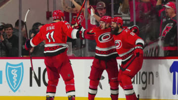 Apr 19, 2023; Raleigh, North Carolina, USA; Carolina Hurricanes right wing Jesper Fast (71) celebrates his game winner with defenseman Brent Burns (8) and center Jordan Staal (11) in the overtime against the New York Islanders in game two of the first round of the 2023 Stanley Cup Playoffs at PNC Arena. Mandatory Credit: James Guillory-USA TODAY Sports