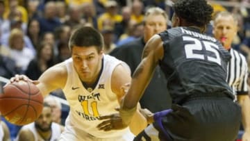 Jan 26, 2016; Morgantown, WV, USA; West Virginia Mountaineers forward Nathan Adrian (11) attempts to drive against Kansas State Wildcats forward Wesley Iwundu (25) during the second half at the WVU Coliseum. Mandatory Credit: Ben Queen-USA TODAY Sports
