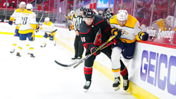 Mar 9, 2021; Raleigh, North Carolina, USA; Carolina Hurricanes center Martin Necas (88) checks Nashville Predators center Yakov Trenin (13) during the first period at PNC Arena. Mandatory Credit: James Guillory-USA TODAY Sports