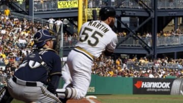 Sep 21, 2014; Pittsburgh, PA, USA; Pittsburgh Pirates catcher Russell Martin (55) hits an RBI single against the Milwaukee Brewers during the seventh inning at PNC Park. Mandatory Credit: Charles LeClaire-USA TODAY Sports