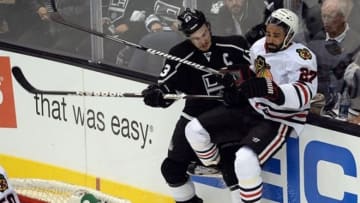 June 6, 2013; Los Angeles, CA, USA; Los Angeles Kings right wing Dustin Brown (23) hits Chicago Blackhawks defenseman Johnny Oduya (27) during the third period in game four of the Western Conference finals of the 2013 Stanley Cup Playoffs at the Staples Center. Mandatory Credit: Jayne Kamin-Oncea-USA TODAY Sports