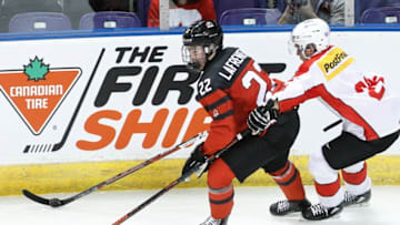 VICTORIA , BC - DECEMBER 19: Alexis Lafreniere #22 of Team Canada skates with the puck while being chased by David Aebischer #26 of Team Switzerland at the IIHF World Junior Championships at the Save-on-Foods Memorial Centre on December 19, 2018 in Victoria, British Columbia, Canada. Canada defeated Switzerland 5-3. (Photo by Kevin Light/Getty Images)"n"n"n"n