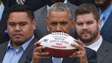 US President Barack Obama holds a football presented to him during an event honoring Super Bowl champion, the New England Patriots, on April 23, 2015 on the South Lawn of the White House in Washington, DC. AFP PHOTO/MANDEL NGAN (Photo credit should read MANDEL NGAN/AFP/Getty Images)