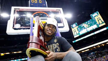 Davion Mitchell #45 of the Baylor Bears sits on a ladder with the trophy after defeating the Gonzaga Bulldogs. (Photo by Jamie Squire/Getty Images)