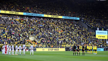 DORTMUND, GERMANY - MARCH 13: Players, officials and fans take part in a minute of silence to indicate peace and sympathy with Ukraine prior to the Bundesliga match between Borussia Dortmund and DSC Arminia Bielefeld at Signal Iduna Park on March 13, 2022 in Dortmund, Germany. (Photo by Christof Koepsel/Getty Images)