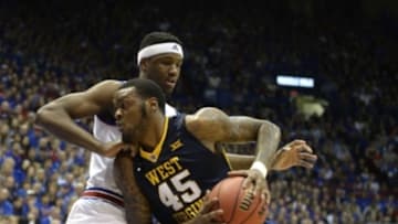 Feb 9, 2016; Lawrence, KS, USA; West Virginia Mountaineers forward Elijah Macon (45) drives to the basket against Kansas Jayhawks forward Carlton Bragg Jr. (15) in the first half at Allen Fieldhouse. Mandatory Credit: John Rieger-USA TODAY Sports