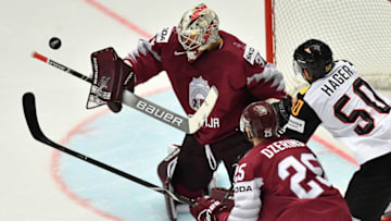 A puck flies by Latvia's goalkeeper Elvis Merzlikins (L) during the group B match Latvia vs Germany of the 2018 IIHF Ice Hockey World Championship at the Jyske Bank Boxen in Herning, Denmark, on May 12, 2018. (Photo by JOE KLAMAR / AFP) (Photo credit should read JOE KLAMAR/AFP/Getty Images)
