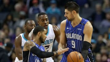 CHARLOTTE, NC - OCTOBER 29: Nikola Vucevic #9 hands the ball off to teammate D.J. Augustin #14 of the Orlando Magic as Dwight Howard #12 of the Charlotte Hornets watches on during their game at Spectrum Center on October 29, 2017 in Charlotte, North Carolina. NOTE TO USER: User expressly acknowledges and agrees that, by downloading and or using this photograph, User is consenting to the terms and conditions of the Getty Images License Agreement. (Photo by Streeter Lecka/Getty Images)
